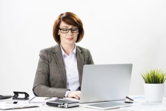 Attractive middle aged businesswoman working with computer in office. Business lady sitting at desk