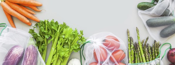 Fresh organic vegetables in eco reusable produce shopping bags flat lay, top view with copy space