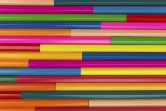 Collection of coloured pencils in a horizontal line pattern as background picture