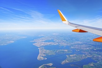 Wing of airplane flying over over the English coast. Traveling concept