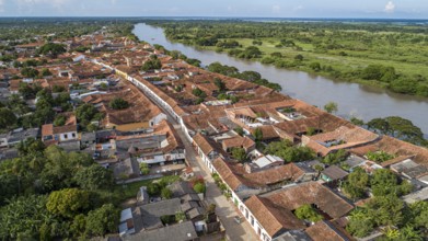 Aerial view of the historic town Santa Cruz de Mompox in sunlight with river and green