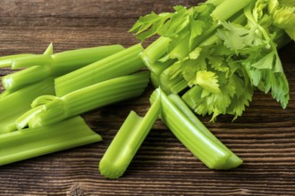 Cut celery sticks and leaves on wooden table