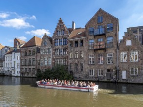 Tourists in the tourist boat for the canal cruise on the river Leie and in the background together