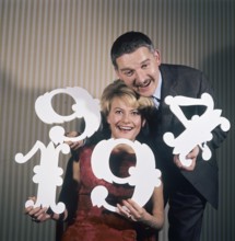 Fun with numbers in the 1960s. A woman and a man are holding different numbers in their hands 1, 4,