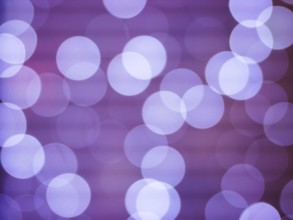 Purple abstract background with bokeh defocused lights. Soft blurred yellow and gold bokeh