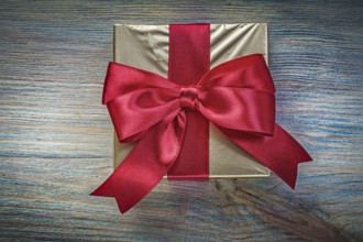Present box with red tape on vintage wooden board holidays concept
