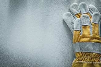 Pair of protective gloves on concrete background copy space
