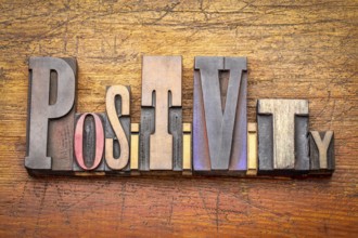 Positivity - word abstract in vintage letterpress wood type against rustic wooden background