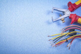 Insulated wire strippers electrical cables on blue background copy space electricity concept