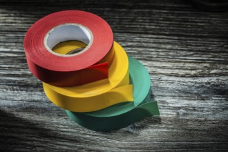 Rolled electricians tapes on wooden board