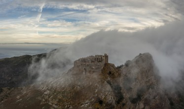 Magazzini, Italy, 14 November, 2023: drone view of the Castello del Volterraio shrouded in morning