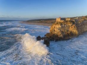 Aerial view of lighthouse on a cliff with a fortress on the coast of the Atlantic ocean with big