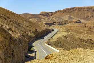 Israeli coast, warm winter February day. Asphalt highway in the ancient mountains on the shores of
