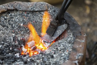 Hot metal arrow blade in the fire before being hammered by a blacksmith