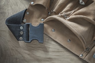 Leather construction belt on wooden board
