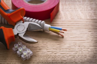 Nippers insulating tape and terminal blocks for electric cables on wooden board