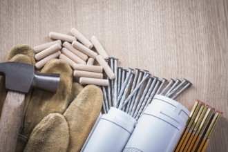 Collection of wooden meter dowels construction drawings claw hammer leather safety gloves and steel