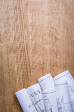 Stack of white construction rolled up blueprints on wooden boards with copyspace