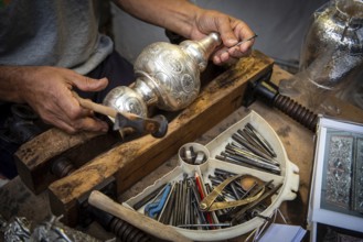 Unrecognized professional Jewellery maker working in workshop crafting silver vase. creative people