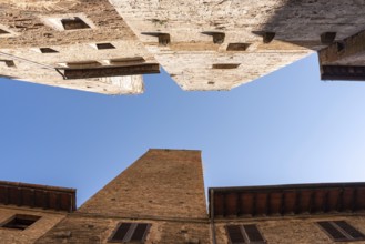 In the streets of San Gimignano, view on the towers Pettini and Salvucci, Italy, Europe