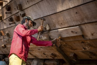 Shipbuilders working on a wooden boat under construction, Mandvi, Gujarat, India, Asia