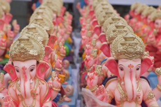 Several small idols of lord Ganesha line up for sale Pune Maharashtra India Asia