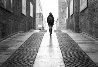 Portugal, 12 28 2018: Young white woman with small backpack walking through the museum of