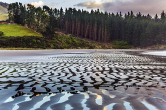 Sunrise over the ocean. Low tide. Strips of sand and water left by the ocean tide. The art of