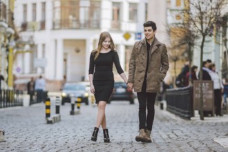 Urban modern young love couple walking romantic talking talking, holding hands on a date. Young