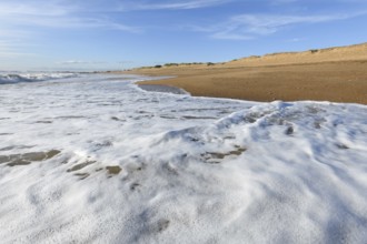 Sea foam on the beautiful sand Atlantic ocean beach in France