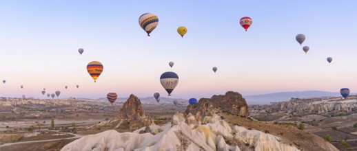 Flying hot air balloons and rock landscape at sunrise time in Goreme, Cappadocia, Turkey, Asia