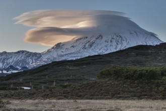 Beautiful clouds over the volcano at sunset. Active Ichinsky Volcano, Kamchatka Peninsula, Far