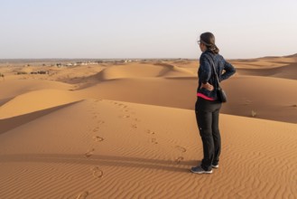 A person walking through the Erg Chebbi desert in the African Sahara, Morocco, Africa