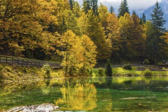 Fantastically beautiful autumn forests are reflected in the water. The quiet lake in Northern