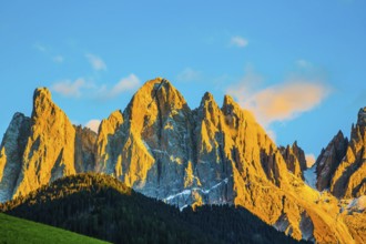 The Dolomites, Tirol. Magnificent serrated cliffs illuminate the summer sunset. The concept of