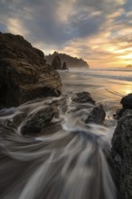 Sunset at a rocky beach with vivid warm colors and beautiful skies