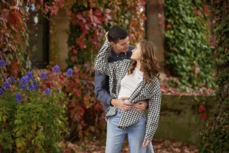 Young Cute Female Hugs Boyfriend. In Autumn Outdoor. Lovers Walking in Park. Attractive Funny