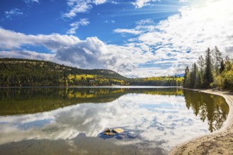 Pyramid Mountain and cumulus clouds is reflected in Pyramid Lake. Cold autumn morning in the Rocky