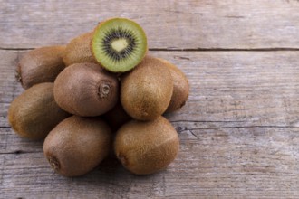 Pile of fresh kiwi on an old wooden board