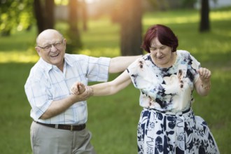 Happy elderly couple. Handsome man and woman seniors. Husband and woman in old age in park
