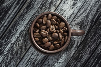 Roasted Coffee Beans In Cup On Wooden Background