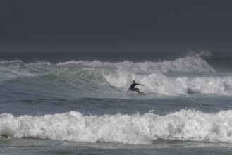 Sidi Ifni, Morocco, 17 March, 2024: man surfing a large wave off the coast of southern Morocco in