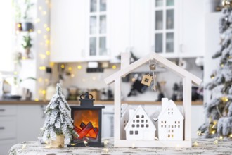Key and tiny house of a small size on cozy home with Christmas decor on table of festive white