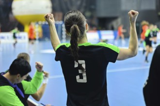 Woman player's back handball match in the background