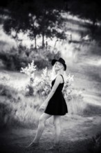 Young blonde woman with black dress in black and white, summertime