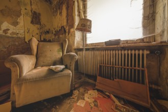 An outdated room with armchair and lamp next to a neglected heating system, Lost Place, Urologist's