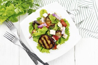 Salad of fried eggplant, fresh tomato with red onion and salted feta cheese, seasoned with
