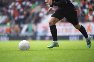 Soccer ball and legs of player during football match