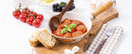 Baked mini meatballs in tomato sauce with basil