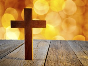 Christian wood cross on blur flare lights and wooden background
